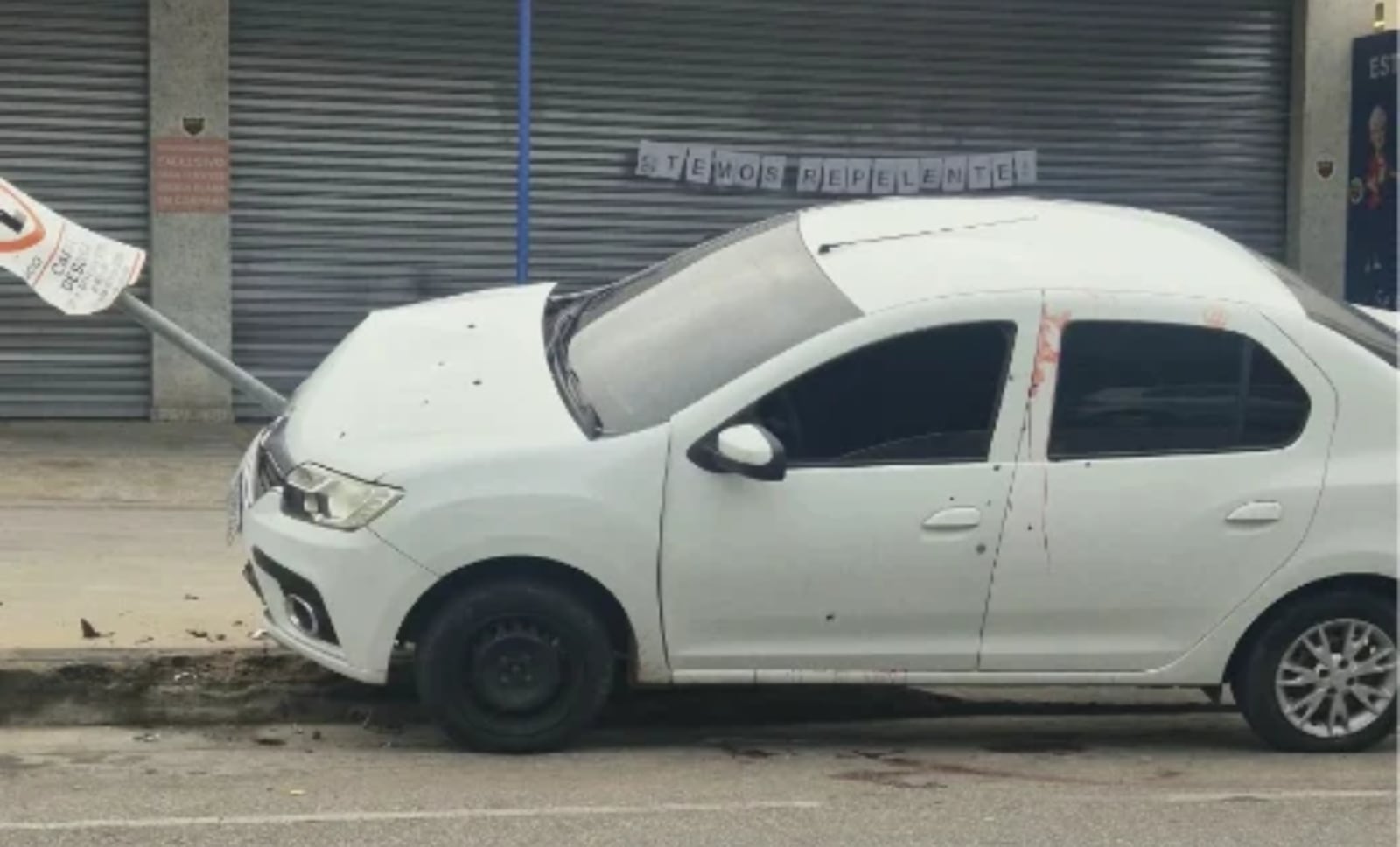 Após os disparos, carro ainda colidiu contra placa de sinalização Reprodução/RECORD MINAS