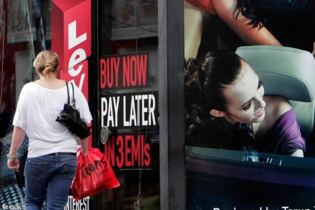 AP A woman walks by a sign ‘Buy now pay later’ at a store in Bangalore, India, on September 10, 2009.